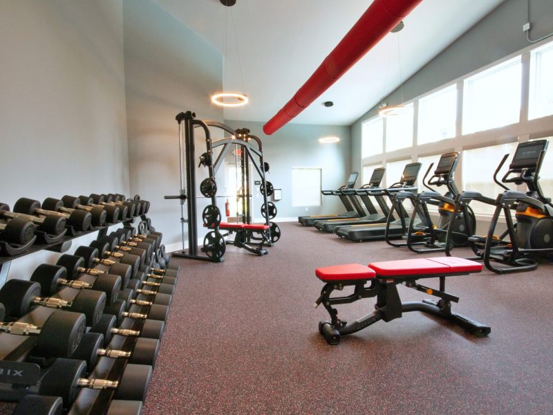 TGM Meadow View Apartments Athletic Club showing dumbbell rack and free weights along with other cardio equipment