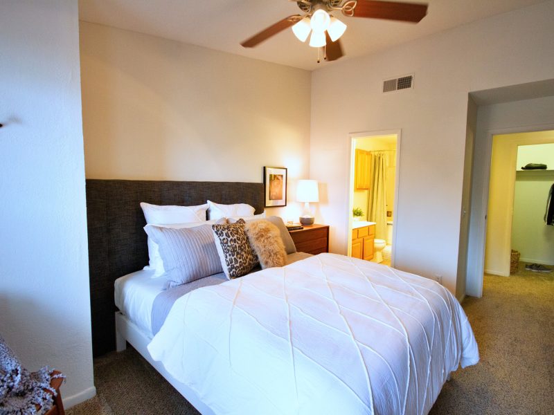 This image exhibits the bedroom area featuring comfy bedding and direct access through the bathroom area.